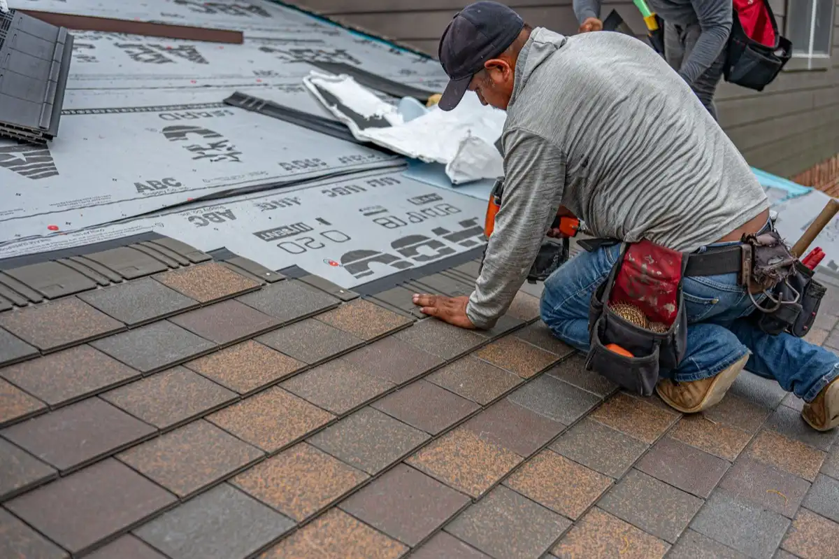 Roofing installer fastening shingles over new underlayment in Lynchburg, VA